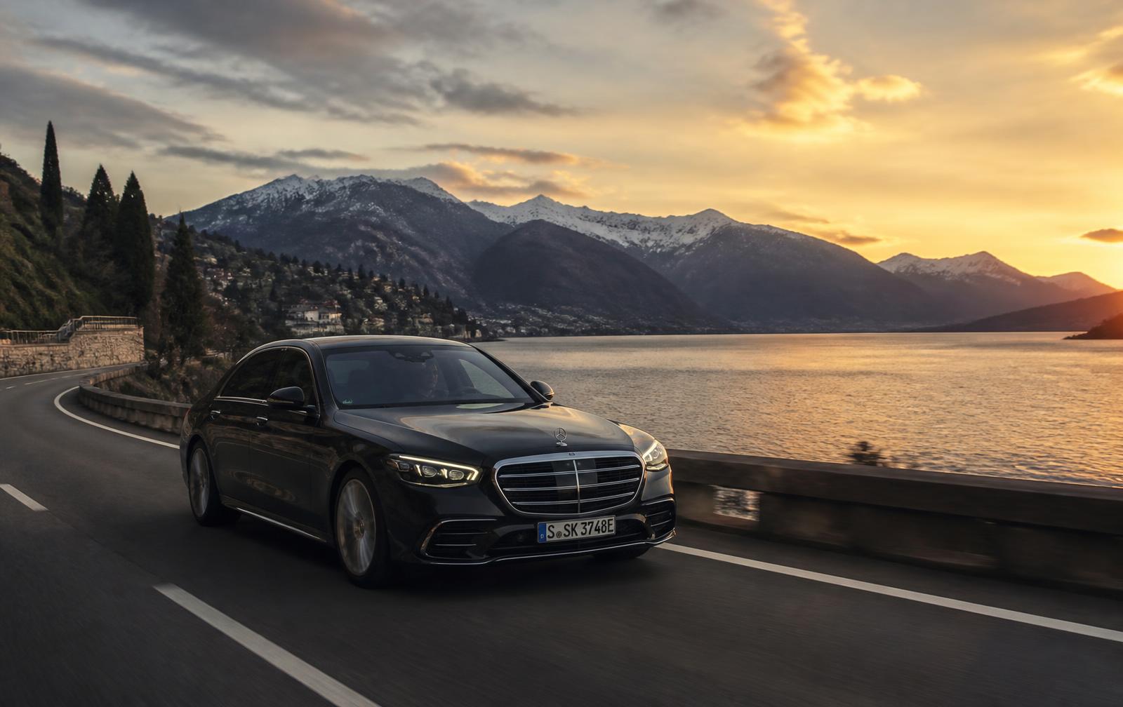 Berline de luxe sur une route au bord du lac Léman avec les Alpes suisses